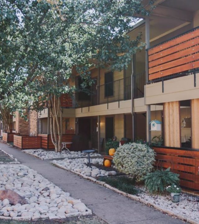 A building with many trees and bushes in front of it